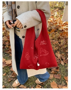 Detail of red felt tote bag with white bird embroidery and woodland forest pattern