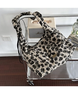 Dettaglio borsa tote leopardata in peluche con placca dorata handmade su tessuto