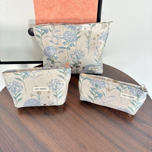 Detailed set of three jacquard canvas makeup bags with blue hydrangea floral patterns