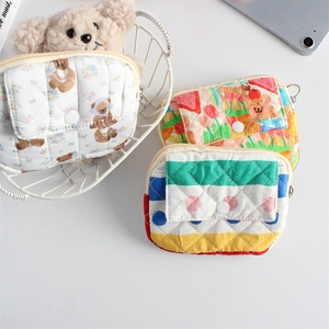 Detailed close-up of quilted floral cotton pouches with bear prints and button closures