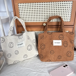 Corduroy lunch tote bag with smile pattern and dual handles in beige and brown colors