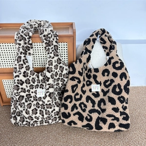 Detail of soft leopard print plush tote bags in grey and yellow faux fur material
