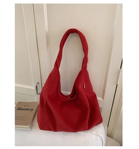 Close-up of a red wool shoulder bag showing soft fleece texture and wide strap detail