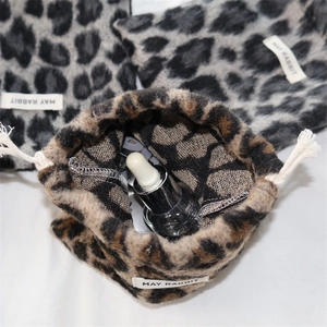 Detail view showing interior space of leopard print drawstring bag with cosmetics
