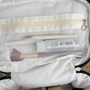 Interior view of makeup bag with white mesh pocket and heart-shaped silver zipper