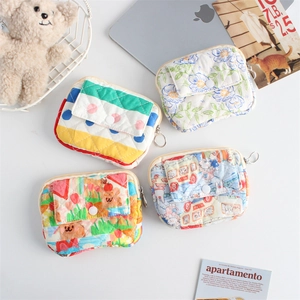 Detailed view of four quilted mini bags with cute cartoon and floral patterns on table