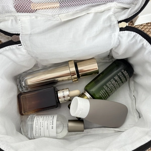 Detail view of the open white makeup bag showing spacious interior with mesh pocket