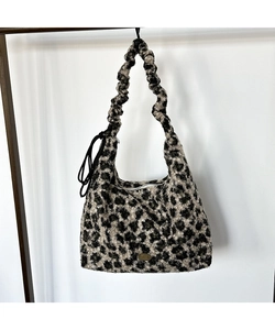 Vista dettagliata della borsa tote leopardata con trama felpata e logo in metallo