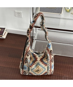 Dettaglio borsa hobo in peluche con motivo bohémien e placca logo in metallo vintage