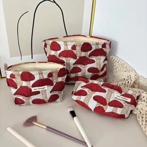 Vue détaillée des trousses de maquillage en toile avec jacquard champignon rouge