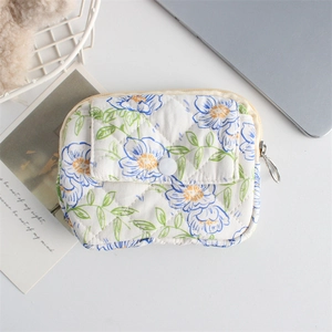 Close-up of quilted floral organizer bag showing blue flower patterns and snap button detail
