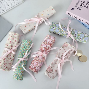 Floral fabric makeup brush roll-up pouches with elegant pink ribbon ties for storage