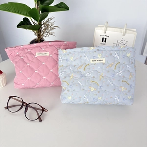 Quilted cosmetic bags featuring heart patterns and character prints on a desk