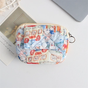 Detailed macro view of quilted floral cotton pouch with snap pocket and metal keyring
