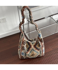 Dettaglio del motivo geometrico etnico sulla borsa in peluche con cerniera vintage