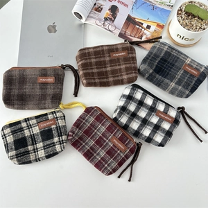 Detailed overhead view of six vintage plaid mini canvas pouches in various colors and textures