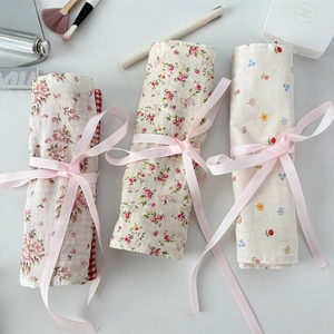 Detail of floral makeup brush rolls with vintage rose patterns and pink ribbon ties