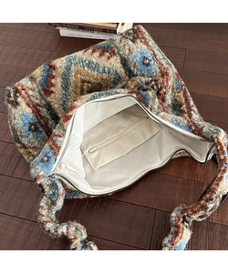 Dettaglio della borsa tote in maglia boho con motivi geometrici etnici e cerniera