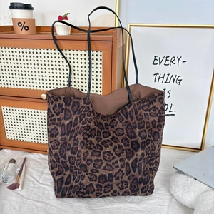 Detail of leopard print tote bag with soft suede texture and leather straps for work