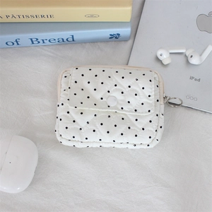 Close-up of heart-quilted earphone pouch with polka dots and metal ring zipper pull