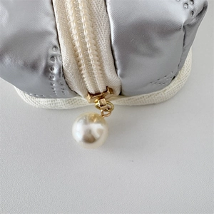 Detail of silver PU mini pouch showing high-quality white zipper and faux pearl pendant