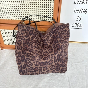 Detail of leopard print faux suede tote bag with slim black leather shoulder straps
