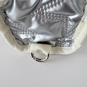 Detail of silver metallic quilted earphone pouch with ribbed edge and metal ring hook