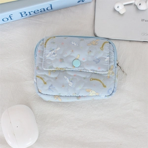 Detail of blue quilted Cinnamoroll pouch with snap pocket and zip closure on desk