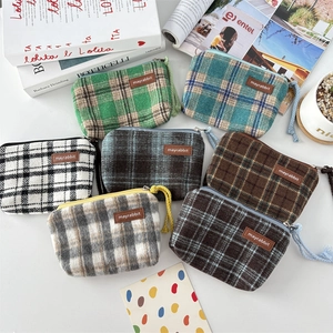 Flat lay of colorful plaid wool coin purses in green, blue, and grey with zipper closures
