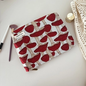 Détail de la trousse à maquillage en toile avec jacquard de champignons rouges