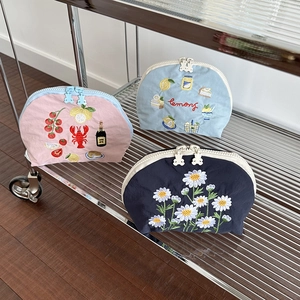 Tre pochette in tela ricamata rosa, azzurro e blu scuro con cerniere a forma di orso