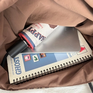 Interior view showing large capacity for tablet, umbrella and books in brown suede tote