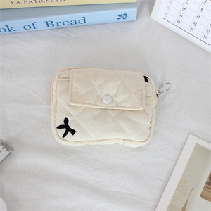 Close-up of quilted floral earphone pouch with black bow embroidery and metal ring hook