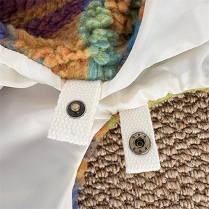 Detail of colorful plush fabric texture with star-patterned metal snap button