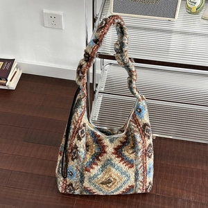 Borsa a spalla bohémien in peluche con motivi geometrici in un interno casa accogliente