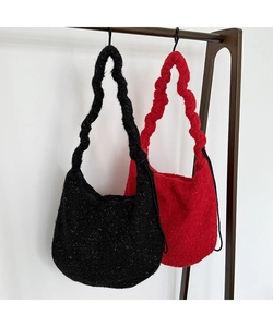 Detail von roten und schwarzen Plüsch-Stricktaschen mit gewellten Schultergurten