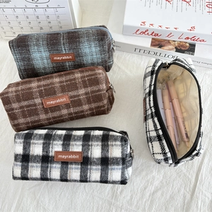Macro shot of plaid wool pencil cases with smooth zippers and spacious interior capacity