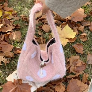 Pink plush tote bag with white flower patterns and a wooden toggle button closure