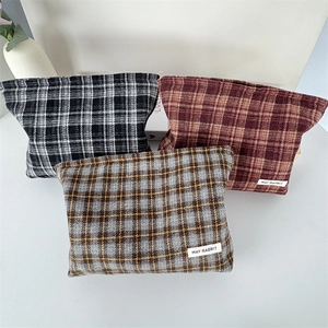 Close-up of high-quality plaid canvas organizer bags in black, red, and grey patterns