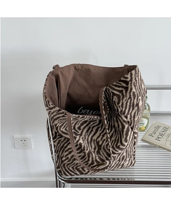 Detail of zebra print tote bag with spacious interior and signature beyond logo label