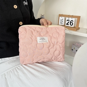 Pink quilted makeup bag with large floral stitching and golden zipper closure