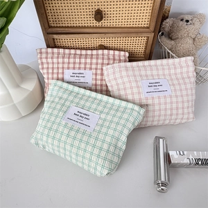 Détail de trois pochettes matelassées à carreaux vert, rouge et rose à texture douce