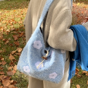 Blue plush tote bag with white floral embroidery and wooden button closure for autumn style