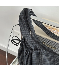 Detail of checkered canvas shoulder bag with silver zipper and drawstring pleats