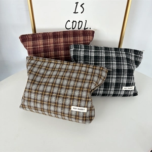 Detailed view of checkered canvas storage bags with zipper closure and logo patch