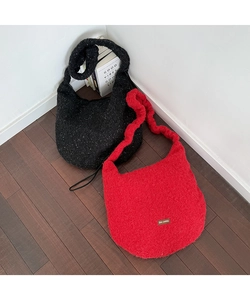 Detailansicht der roten und schwarzen Plüsch-Tragetaschen mit weicher Strickstruktur