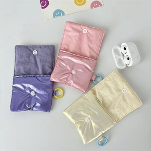 Quilted silk-textured AirPods cases in purple, pink and beige with snap closure hooks