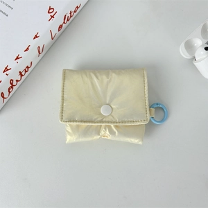 Detail of light beige puffy quilted headphone case with white snap and blue ring hook