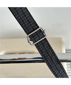 Close-up of black and white checkered canvas strap with silver metal adjustment buckle