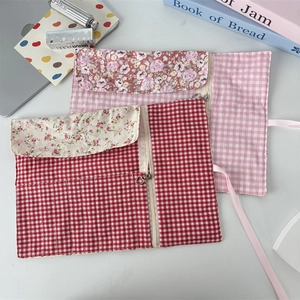 Flat lay of floral cotton roll-up makeup brush pouches with plaid patterns and silk ties